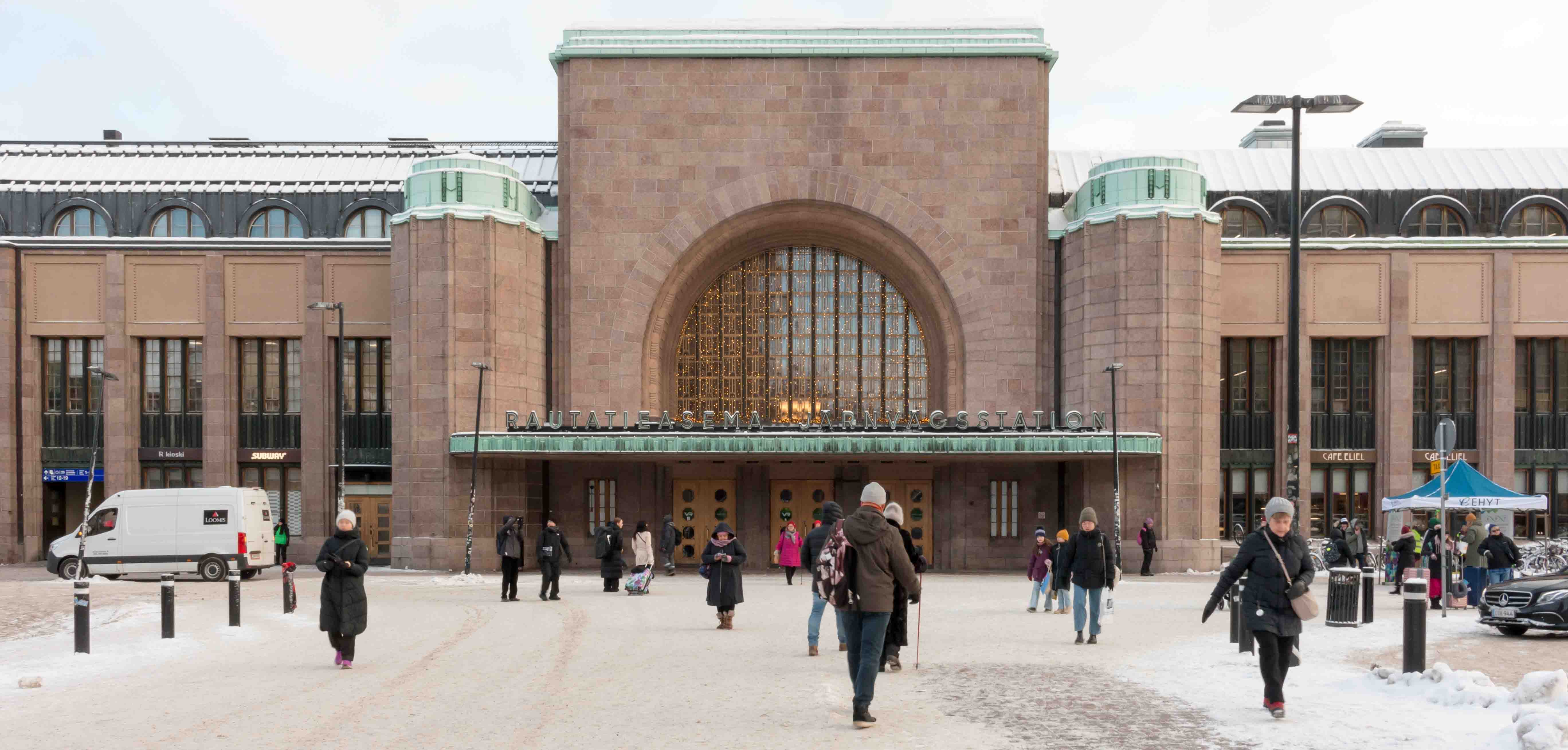 Kävelevät ihmiset Helsingin päärautatieaseman edessä